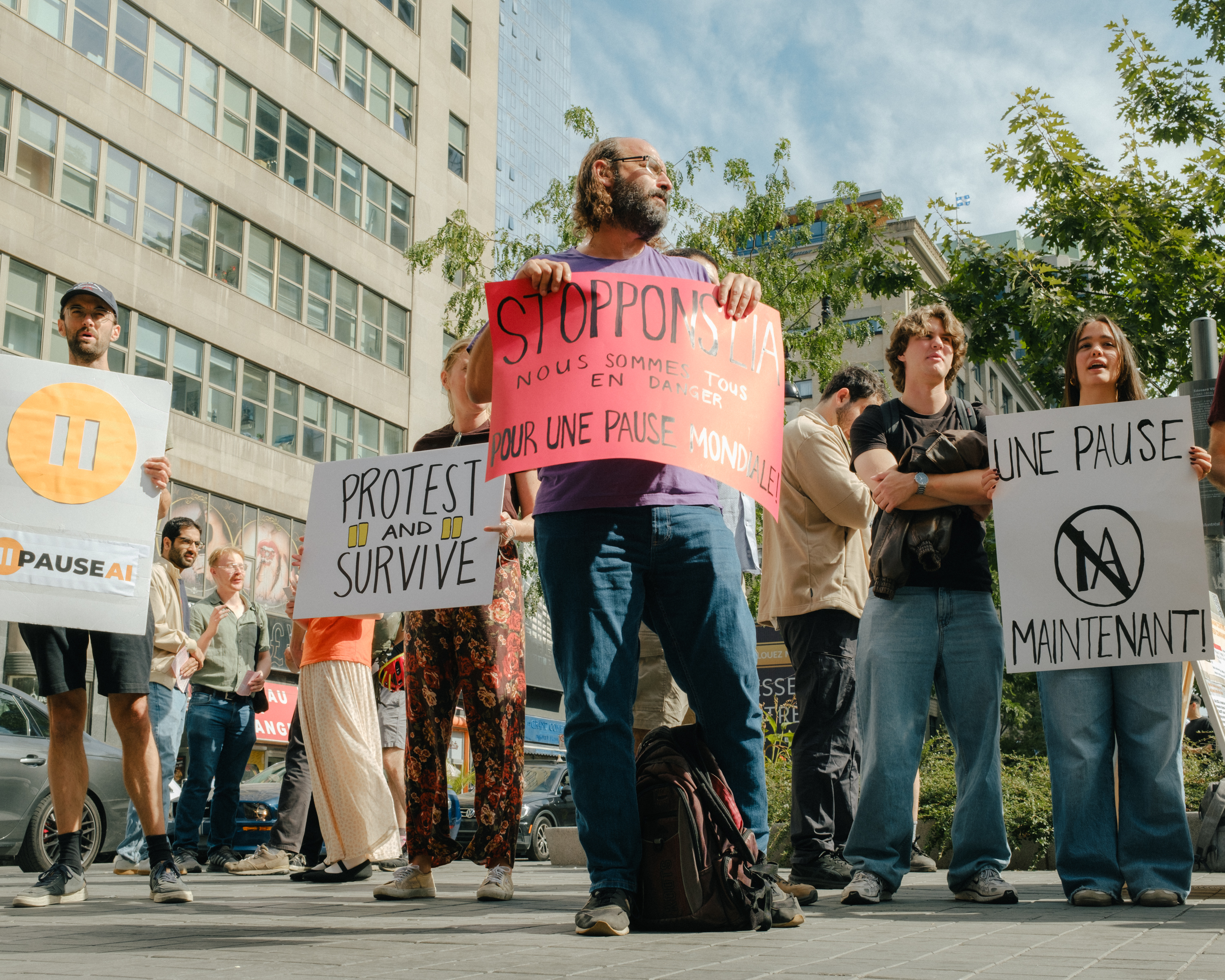 Demonstrators holding signs calling for a worldwide pause on AI